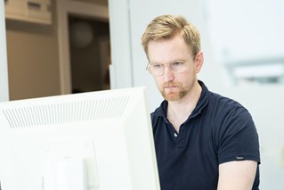 Tandläkare arbetar vid klinikens CEREC scanner-dator.