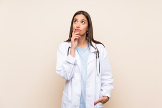 Köpt bild av funderande läkare, licens Adobe Young doctor woman over isolated background thinking an idea